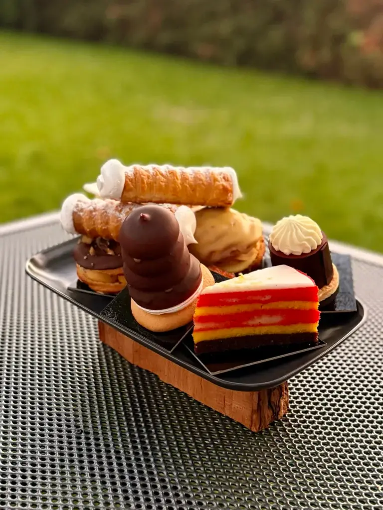 Seven Czech pastries from Cukrář Skála on one plate in a Prague garden