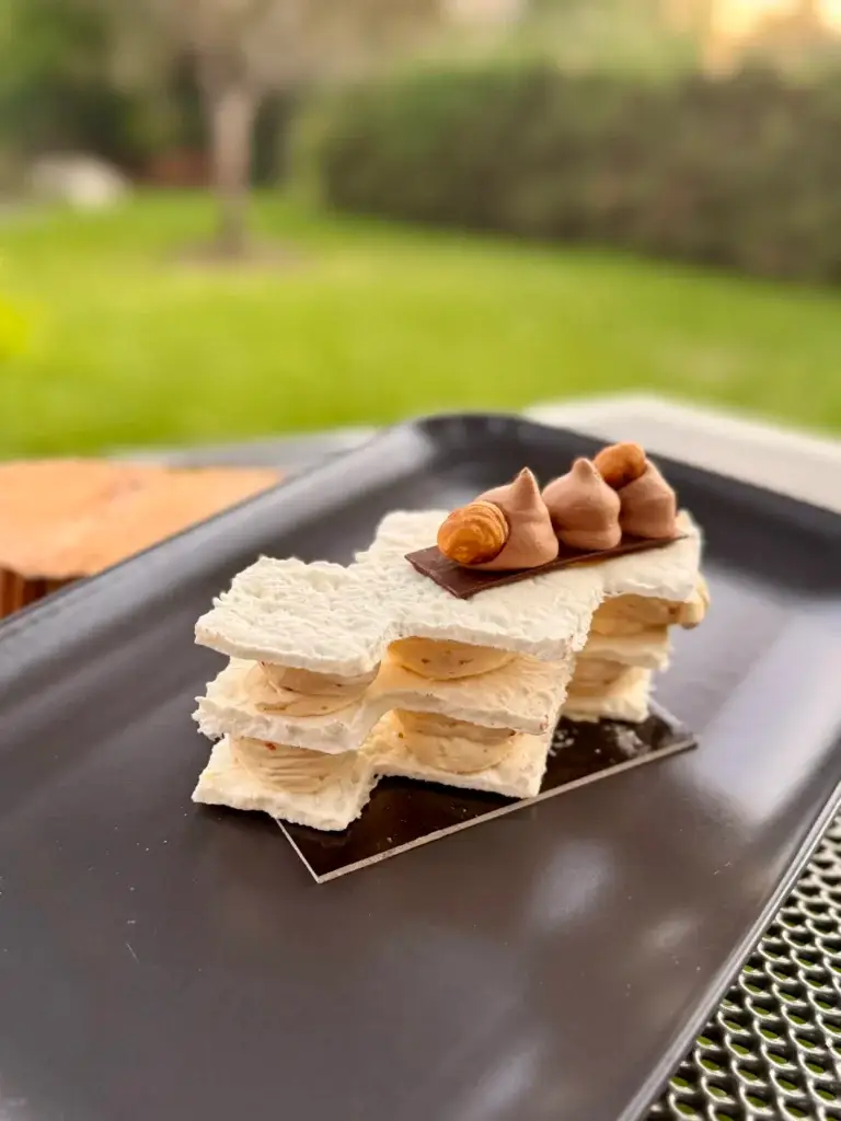 Laskonka, coconut meringue layers with nut cream and hazelnuts