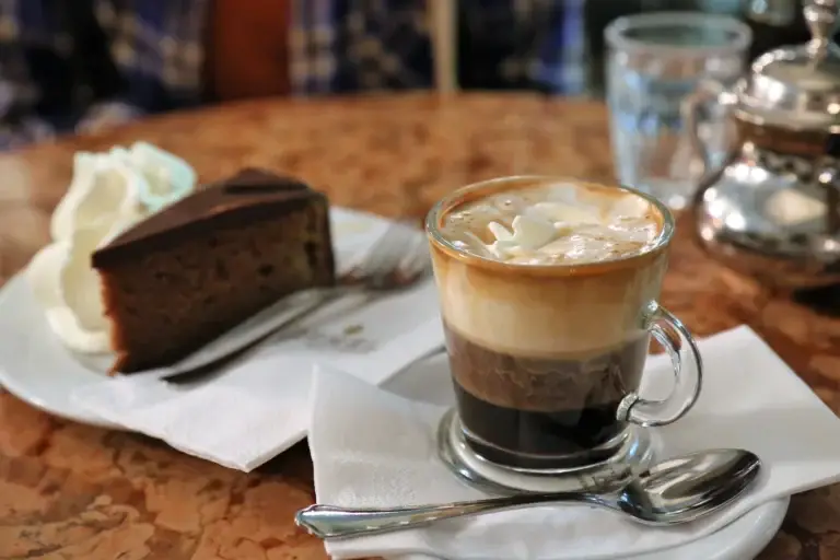 Viennese coffee served with a slice of Sachertorte on a café table